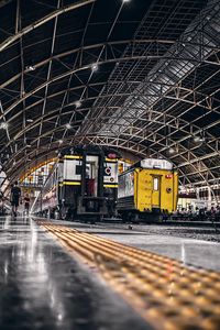 Illuminated railroad station by building in city