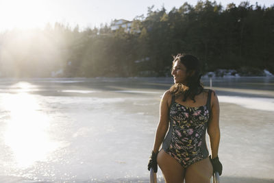 Smiling woman wearing swimwear at river