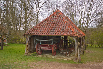 Old house on field against trees