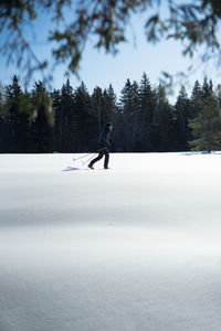 Side view of person walking on snow covered landscape