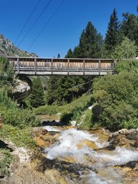 Bridge over river against clear blue sky