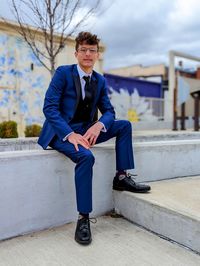 Low section of man sitting on wall