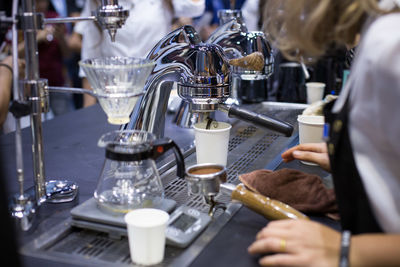 Midsection of woman pouring coffee in cafe