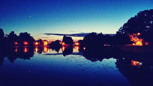 Reflection of trees in water at dusk