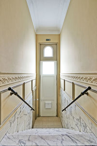 Entrance door and marble stairs in renovated mansion stairwell