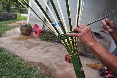 Hands of craftsperson weaving bamboo basket