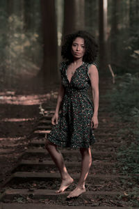 Portrait of a beautiful young woman standing on land