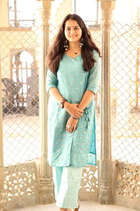 Portrait of smiling young woman standing against fence