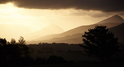 Scenic view of silhouette mountains against sky at sunset