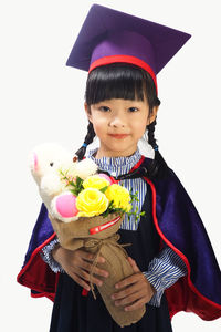 Portrait of a boy holding toy against gray background