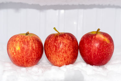 Close-up of apples on table against white background