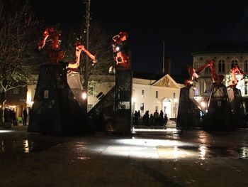 People in illuminated city at night