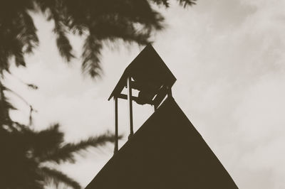 Low angle view of silhouette cross against sky