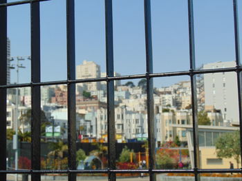 Buildings against clear sky seen through glass window