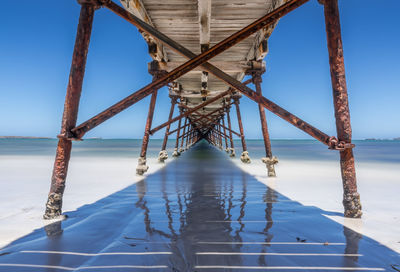 Low angle view of bridge over sea against sky