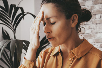 Young woman looking away against wall