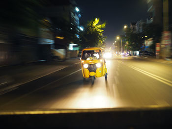 Fast moving tuk tuk, also known as auto rickshaws, riding along the night streets of phnom penh. 
