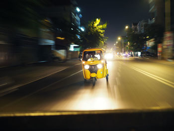 Car on illuminated street at night