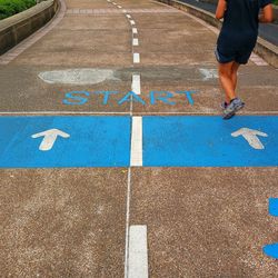 Low section of man running on road with start text 