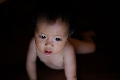 Baby looking a notebook on black background