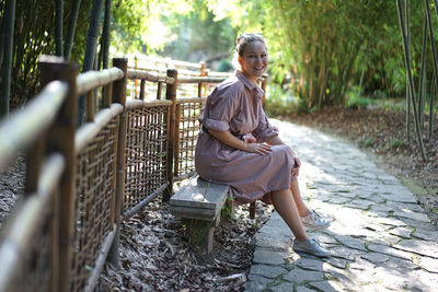 Full length of woman sitting outdoors