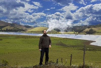 Full length of man standing on field against sky