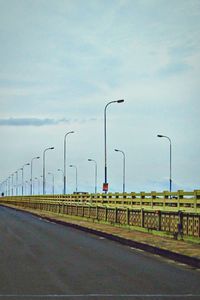 Empty road against cloudy sky