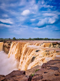 Panoramic view of waterfall against sky