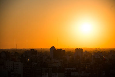 Silhouette buildings against sky during sunset