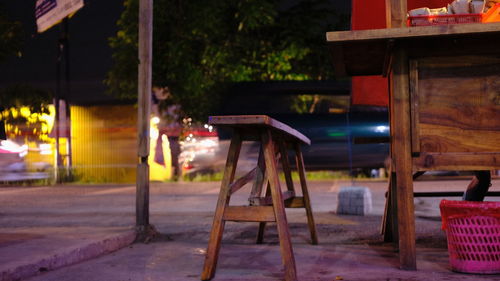 Empty chairs and tables in illuminated building at night