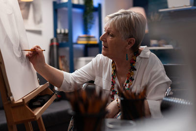 Senior woman painting at home