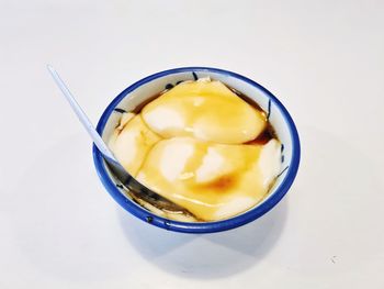 Close-up of egg in glass on white background
