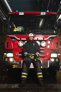 Portrait of fire fighter in front of fire engine