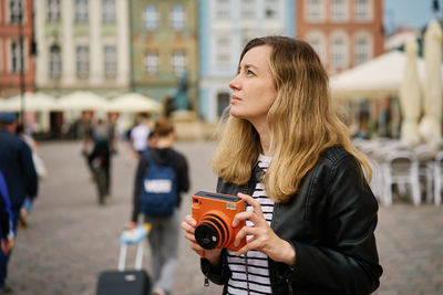 Female traveler taking picture with vintage instant camera