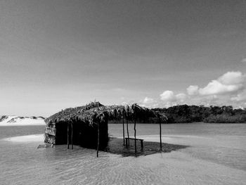 Wooden posts on beach against sky