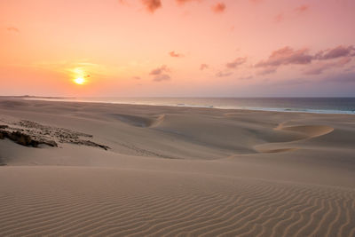 Scenic view of beach against sky during sunset