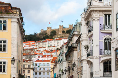 Low angle view of buildings in town against sky