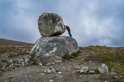 Male tourist at stoneblock at steinplassen road 51, north of valdresflye, norway