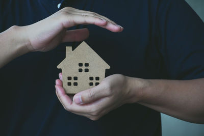 Close-up of hand holding toy against house in building