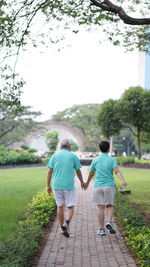 Rear view of couple walking on footpath