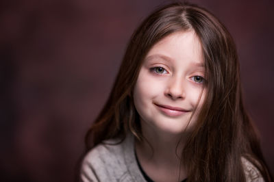 Close-up portrait of girl against brown background