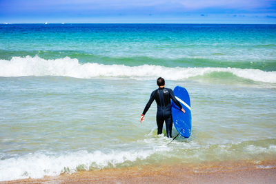 Rear view of man standing at beach