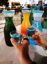 Close-up of hand holding drink on table