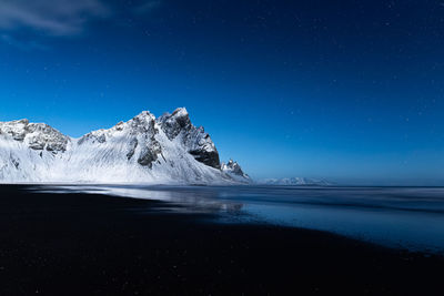 Scenic view of sea against clear blue sky at night