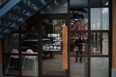 Reflection of man on glass window in restaurant