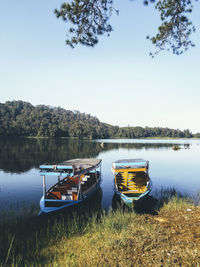 Boats moored in lake against sky