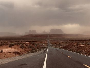 Road leading towards mountain against sky