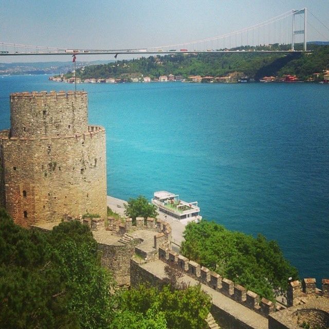 architecture, built structure, building exterior, water, sea, blue, connection, high angle view, travel destinations, sky, famous place, tree, bridge - man made structure, city, history, tourism, river, travel, day, clear sky