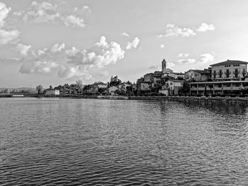 View of cityscape by sea against sky