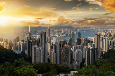 Modern buildings in city against sky during sunset